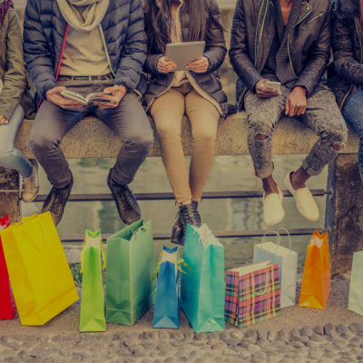 Group of friends sitting outdoors with shopping bags - Several people holding smartphones and tablets - Concepts about lifestyle,shopping,technology and friendship
